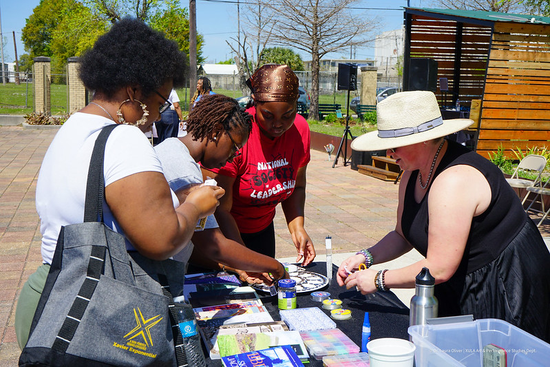 Four people standing around a table doing an art project.