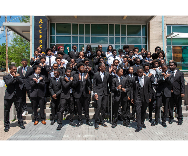 Men of Xavier standing on a staircase outside of a building in black suits