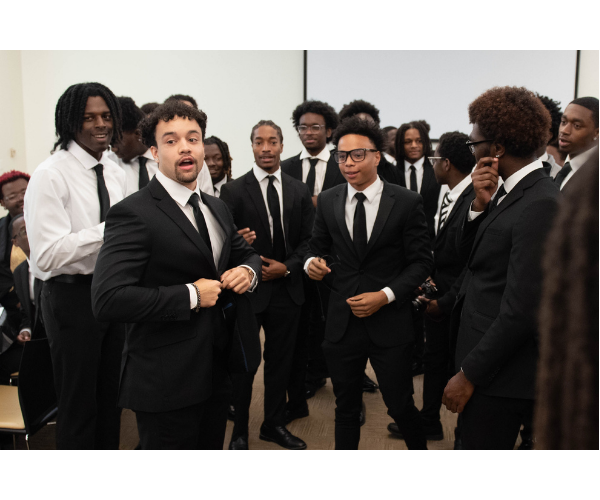 Men of Xavier, wearing black suits, bond with a friendly rock-paper-scissors tournament