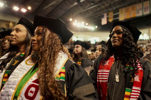 Students wearing black caps and gowns at a graduation ceremony