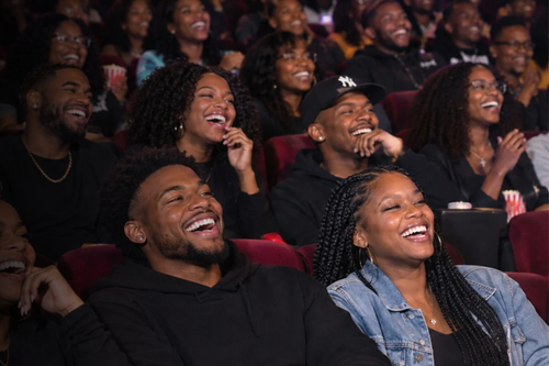 People in an audience laughing