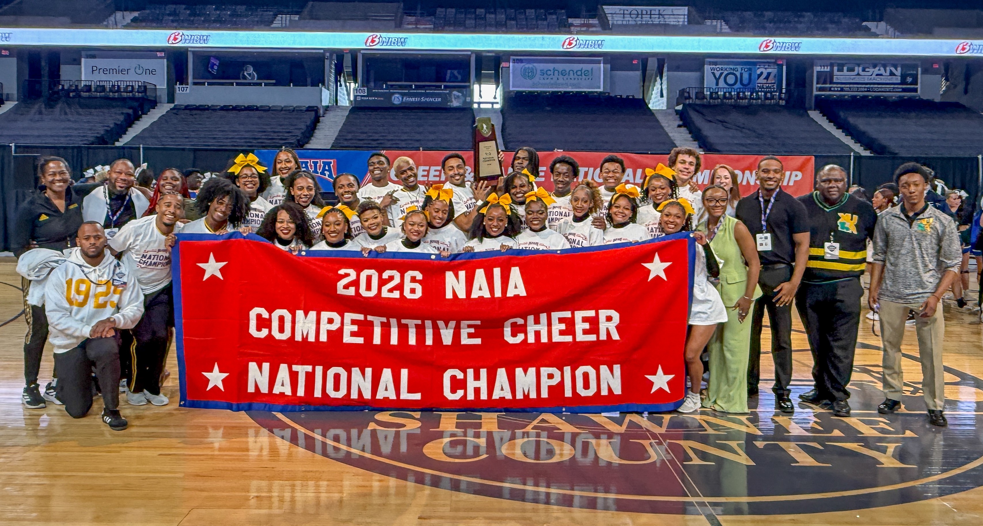 Xavier University of Louisiana cheer team, coaches holding up banner that reads "2026 NAIA Competitive Cheer National Champion"