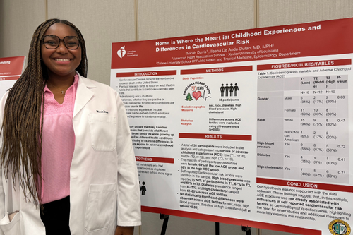 Micah Davis standing with poster displaying her research